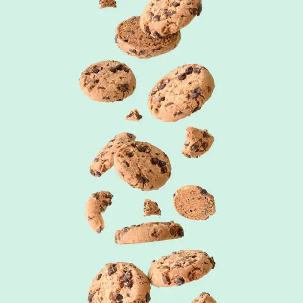 Photo of Chocolate chip cookie floating on a green background.