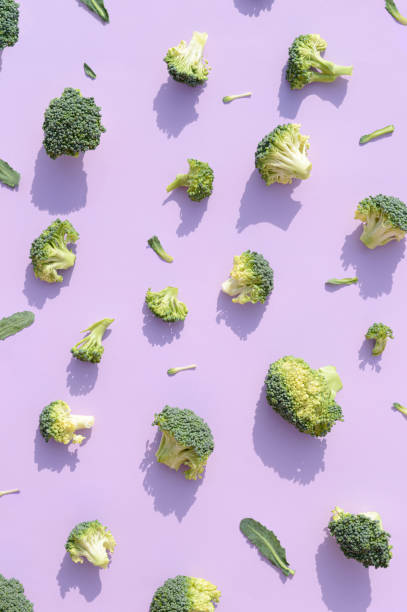 istock Broccoli arranged on a purple background. 1386732372