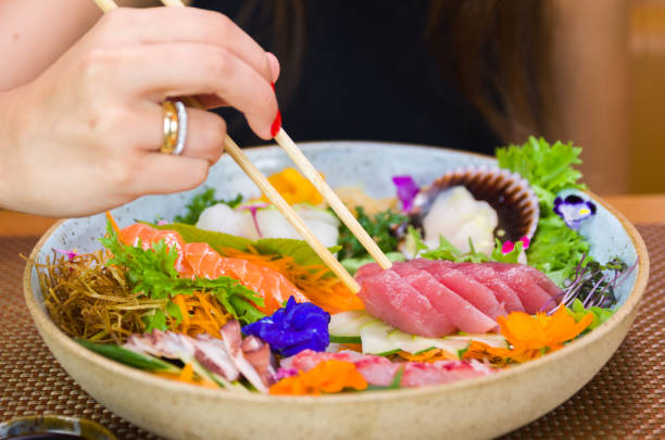 istock Woman eating delicious sushi 1386732404
