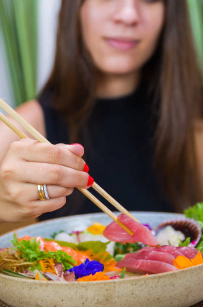 istock Woman eating delicious sushi 1386733029