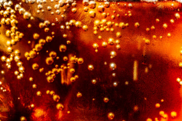 macro soft drink texture,Soft drink glass with ice splash on dark background. Cola glass in celebration party concept.