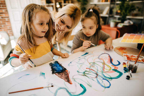 istock Mother and daughters painting 1386736582