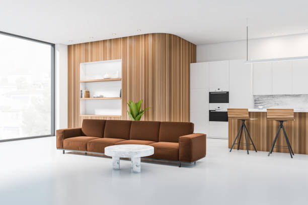 istock Stylish kitchen interior with sofa and bar seats with shelves, panoramic window 1386737896