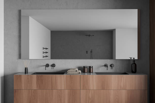 istock Bright bathroom interior with mirror and sinks, shower, grey walls 1386738221