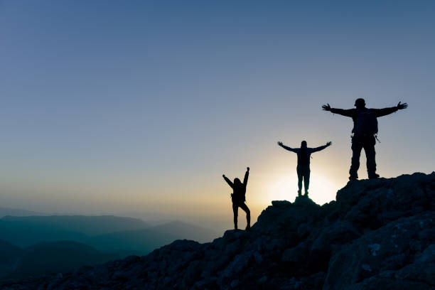 istock Teamwork couple climbing and reaching mountain peak 1386739397