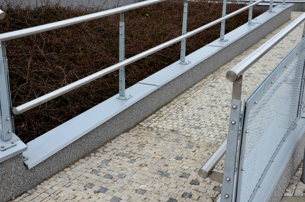istock railing with two handrails. made of galvanized steel prisms. the lower railing is a protection against wheelchairs. ramp for the immobile in the housing estate, stainless steel, staircase, ramp 1386740202