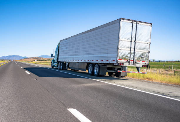 Green big rig semi truck with cargo in refrigerator semi trailer standing out of service on the road shoulder in Washington Broken green big rig semi truck with extended cab for long haul and refrigerator semi trailer standing out of service on the road shoulder in Washington waiting for mobile towing roadside assistance agricultural machinery shipping stock pictures, royalty-free photos & images