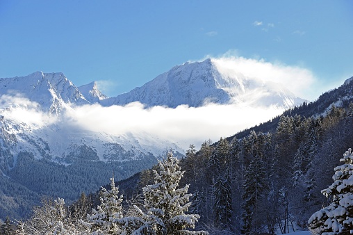 Winter scenery  with snowcapped mountain under clouds