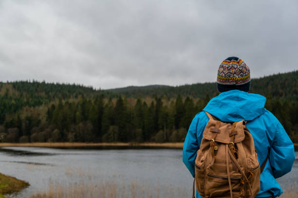istock Senior man looking at a loch in a rural location 1386743596