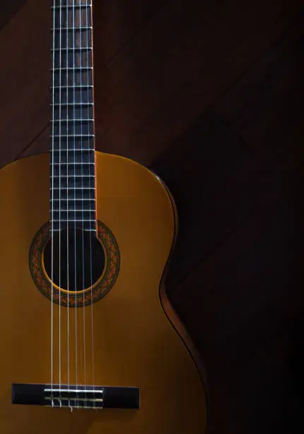 Photo of top view of classic yellow acoustic guitar with nylon strings.