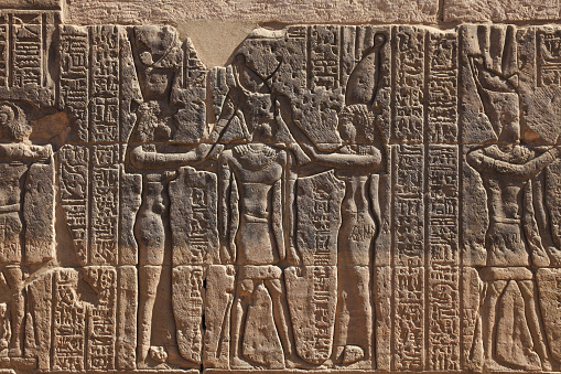 Namer uniting Upper and Lower Egypt hieroglyphic at Temple of Philae in Aswan, Egypt. The Deshret [right] headwear of Upper Egypt and the Hedjet [left] headwear of Lower Egypt. They were combined to form the Pschent [center], during the unification of Egypt and the start of the First Dynasty.