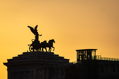 Altare della patria or altar of the Fatherland, silhouette view of the bronze sculpture of a chariot at the top of it at susnet