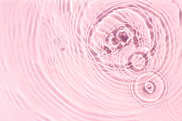 istock Texture of drops on pink water under sunlight. Top view, flat lay 1386753485