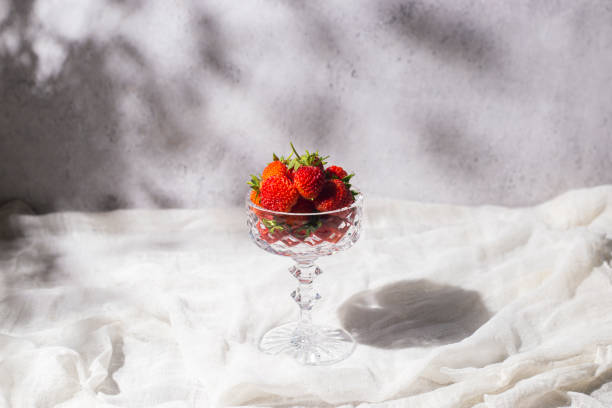 istock Fresh red strawberries in a glass on a table on a concrete background 1386753512