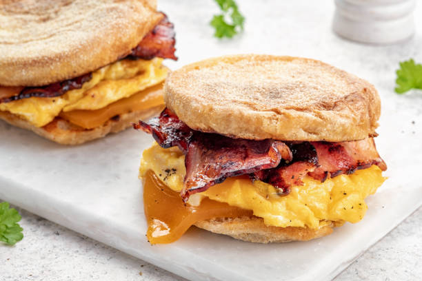 istock English muffin, egg, ham, and cheese breakfast sandwich on a cutting board 1386753676