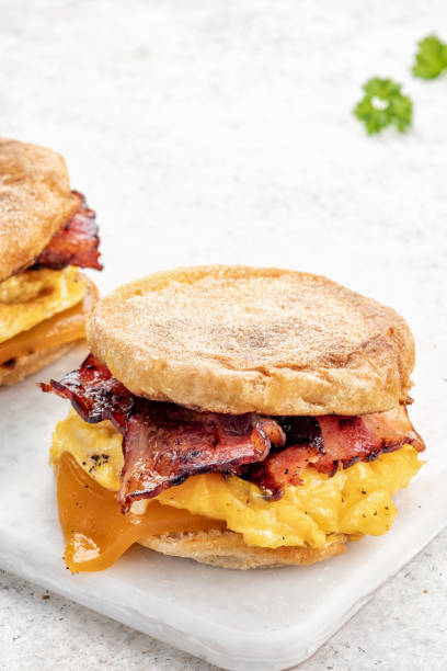 istock English muffin, egg, ham, and cheese breakfast sandwich on a cutting board 1386753697