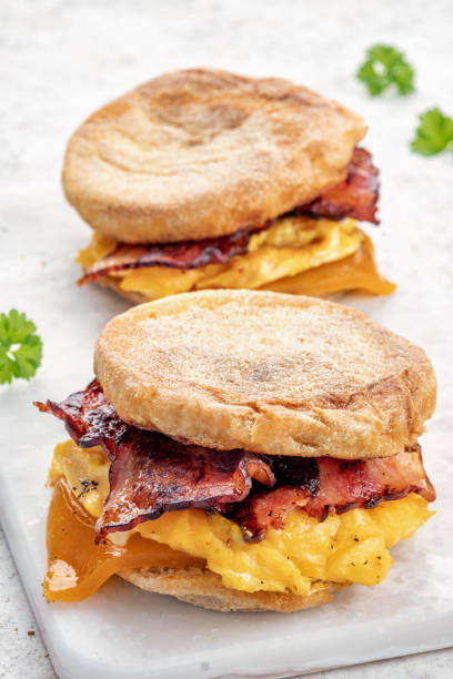 istock English muffin, egg, ham, and cheese breakfast sandwich on a cutting board 1386753708