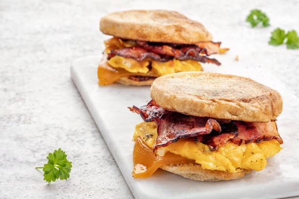 istock English muffin, egg, ham, and cheese breakfast sandwich on a cutting board 1386753725