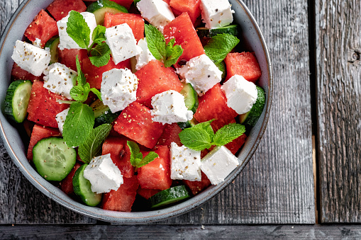 Summer salad with watermelon, mint, cucumber and feta cheese close up. Shadows