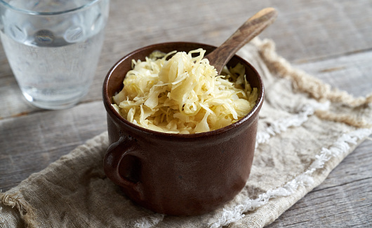 Homemade fermented cabbage or sauerkraut in a pot with a spoon