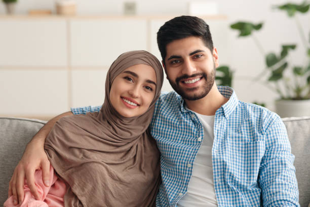 istock Smiling Middle Eastern Couple Embracing Sitting On Couch At Home 1386757656