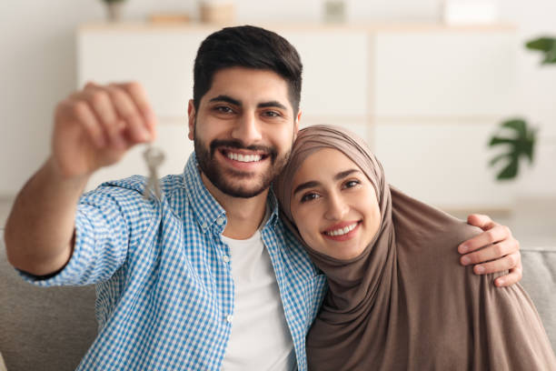 istock Joyful Middle Eastern Couple Showing Key Smiling Sitting At Home 1386758651