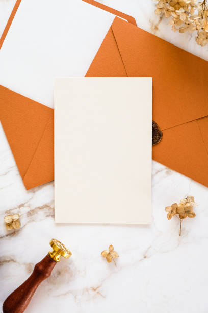 istock Blank wedding invitation and bronze envelopes on marble table. Flat lay, top view, copy space. 1386759690