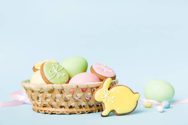 istock Colorful easter cookies in basket with Multi colors Easter eggs on colored background . Pastel color Easter eggs. holiday concept with copy space 1386759988