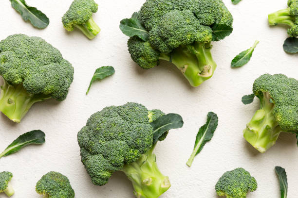 istock green fresh broccoli background close up on colored table. Vegetables for diet and healthy eating. Organic food 1386760059