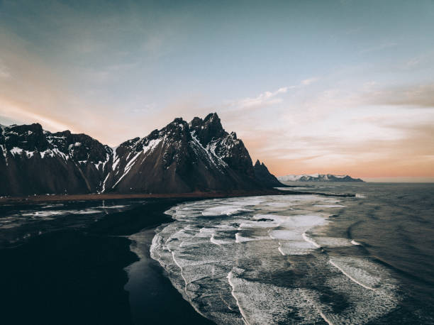 Iceland Vestrahorn Mountain Range Black Beach Sunset Vestrahorn Mountain Range Panorama, Stokksnes, Southeast Iceland. Volcanic Black Beach at Vestrahorn Mountain in Winter. Beautiful Black Beach and Sea and iconic Mountain Range. Winter Skyscape. Stiched <drone Point of View Panorama. Vestrahorn Mountain Range, Stokkness, South East Iceland, Nordic Countries, Northern Europe. golden circle route photos stock pictures, royalty-free photos & images