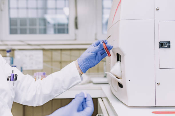 istock female microbiologist studying blood sample - protective workwear 1386766536