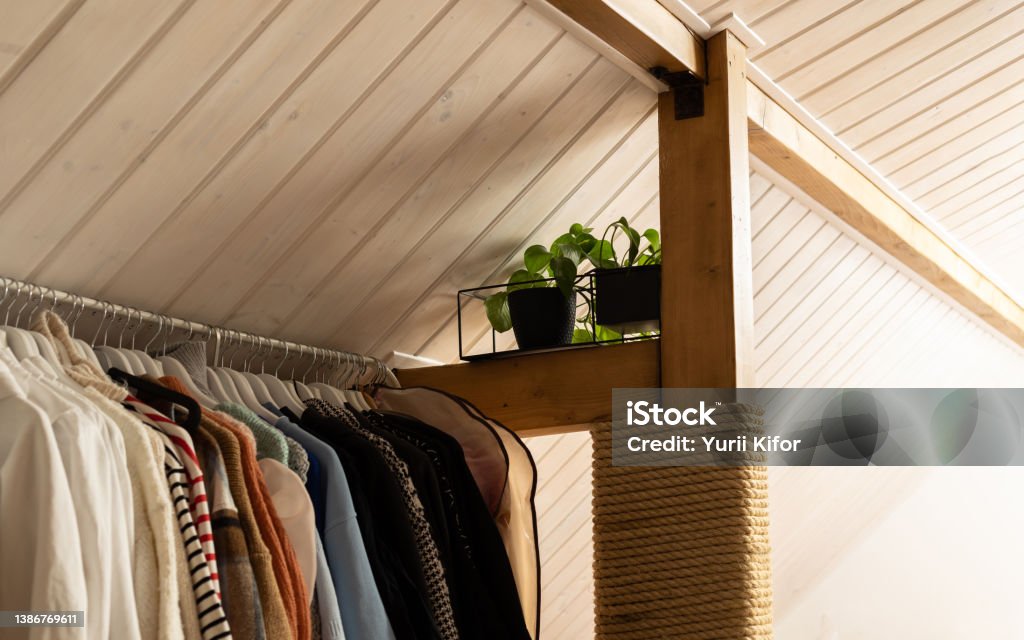 Wardrobe in the bedroom on the attic floor in white. Beam with a rope for a cat's nails. Attic Stock Photo