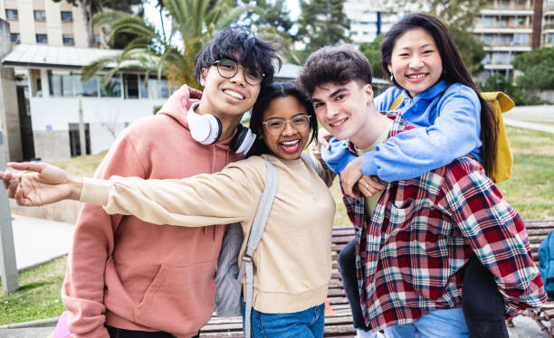 istock Cheerful multiracial young students friends standing at campus college 1386771012