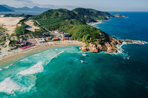 Popular Joaquina beach with rocks and Atlantic ocean with waves in Brazil. Aerial view