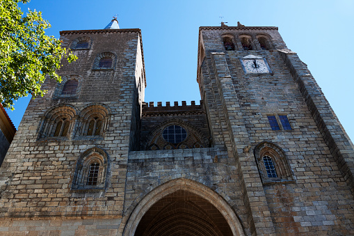 The two towers at the front of the cathedral in Evora, Portugal. Wide angle view from below.