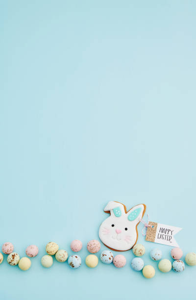 istock Easter cookie decoration with a HAPPY EASTER message on a blue background with speckled chocolate Easter eggs 1386783979