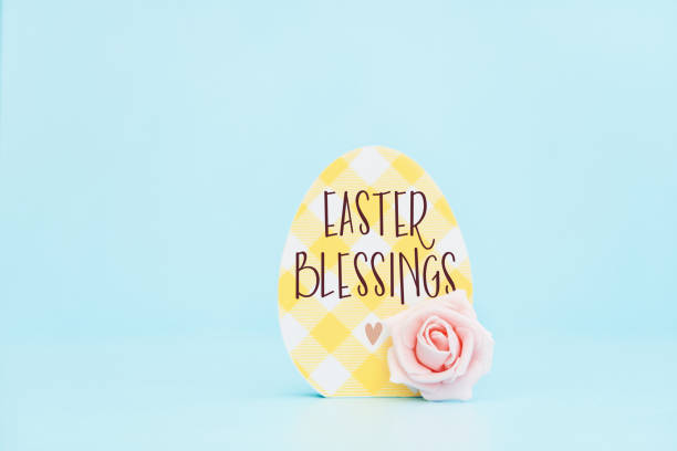 Cute Easter background with a wooden egg shape and rose with an Easter message. Copy space for adding additional text