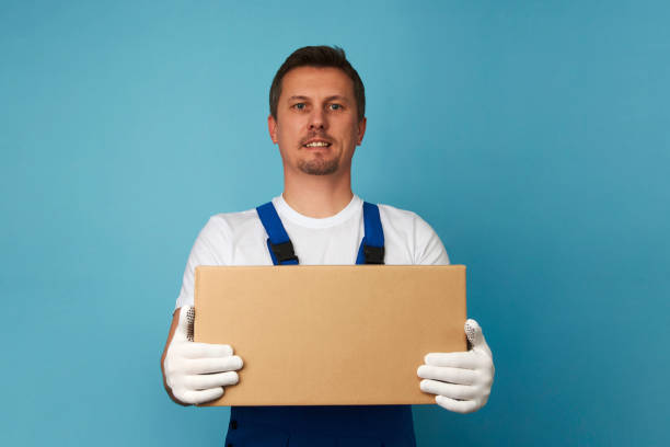 istock Delivery man with cardboard box on a blue background 1386784335