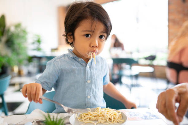 istock Adorable malay boy enjoying his lunch at a local restaurant 1386793302
