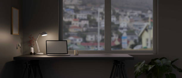 istock Modern home office workspace in the evening with laptop computer 1386794893