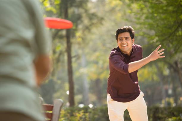 istock Man throwing frisbee at park 1386802333