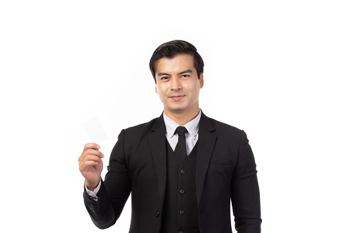 Handsome business man in black suit holding credit card isolated on white background. Business, technology, ecommerce and online payment concept.