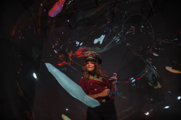 istock Female magician makes with soap bubbles show, an illusionist 1386813559
