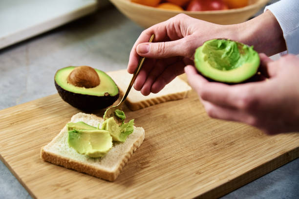 istock Ripe avocado in woman hands, Healthy breakfast 1386814341