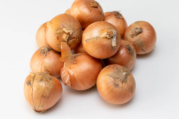 istock Lots of onions on the white table 1386815613
