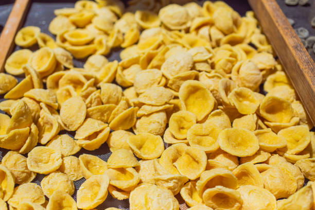 rohe hausgemachte pasta auf der straße in italien. traditionelles essen - orecchiette stock-fotos und bilder