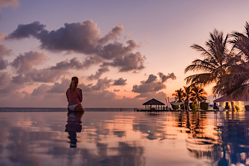 Reflection of beautiful clouds in the pool at sunset and Phuket Island.