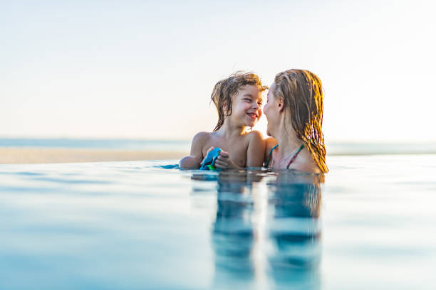 istock Happy single mother and her boy talking in the pool. 1386822911