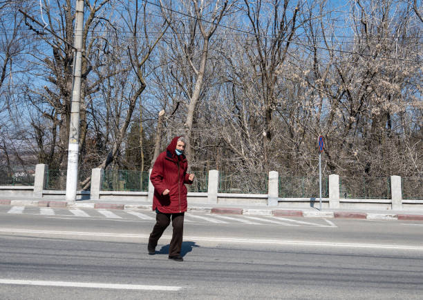 une vieille femme traverse la rue à la hâte. - titre dalbum photos et images de collection