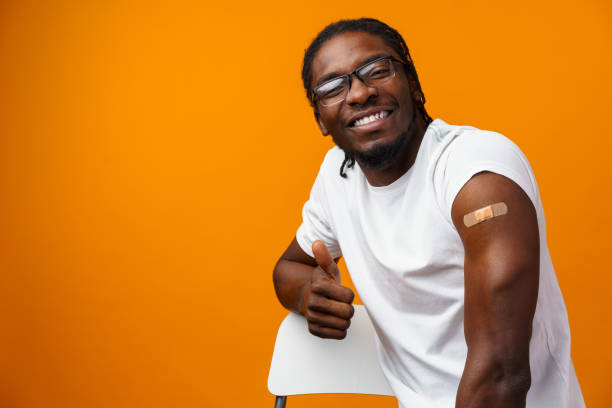 istock Young black man got vaccinated from coronavirus against yellow background 1386823663